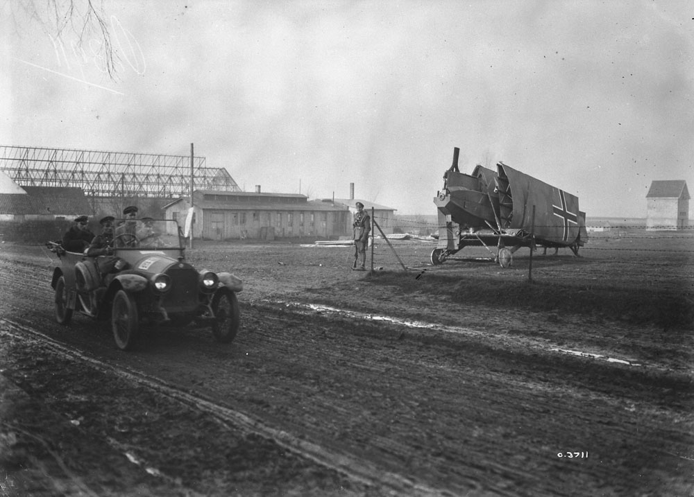 Nov. 1918. There is a lot of interest in this photo. The soldier guarding the plane, the enorous Zeppelin shed, and the officer"s car in the foreground.
